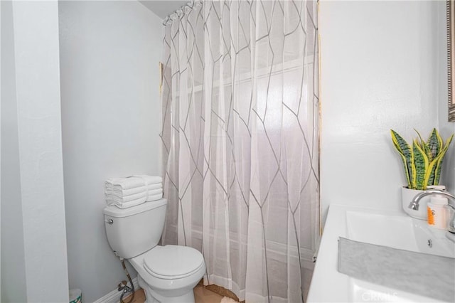 bathroom featuring toilet, shower / bathtub combination with curtain, and a sink