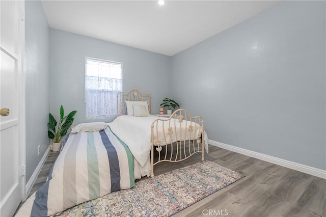 bedroom with baseboards and wood finished floors