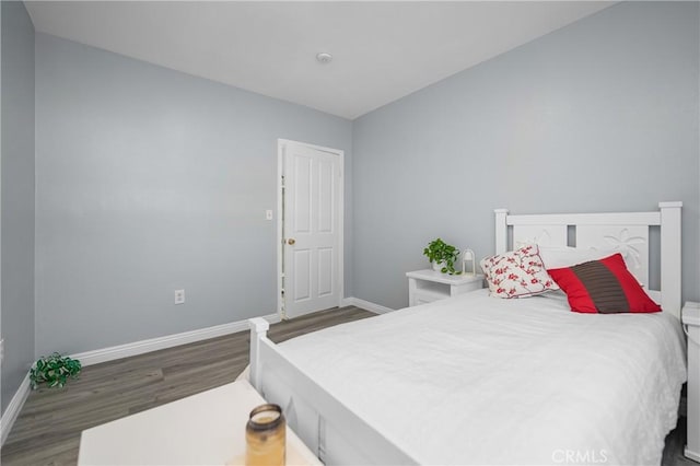 bedroom featuring wood finished floors and baseboards