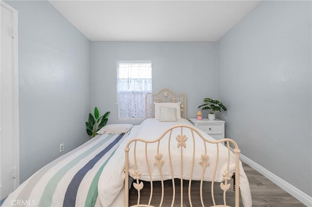 bedroom featuring wood finished floors and baseboards