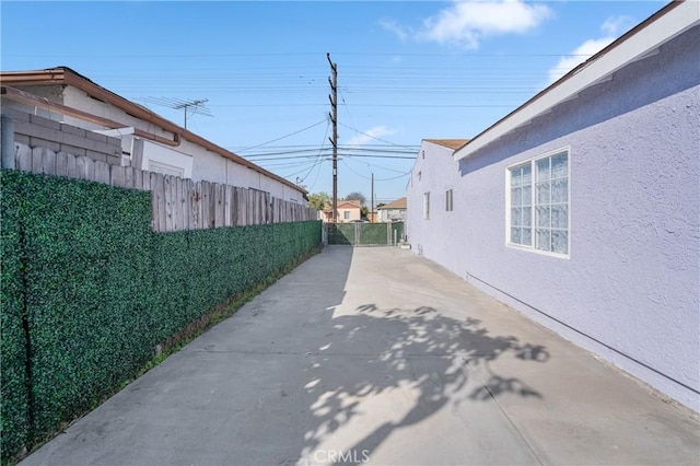 view of street featuring driveway and a gate