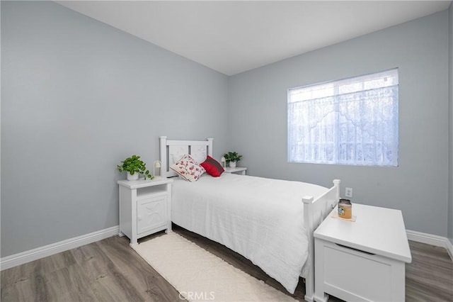 bedroom featuring baseboards and wood finished floors