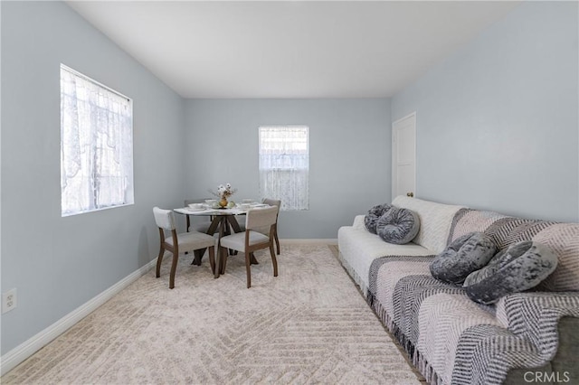 dining space with baseboards, carpet, and a healthy amount of sunlight