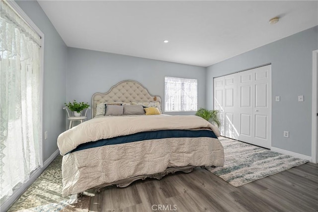 bedroom featuring a closet, baseboards, and wood finished floors