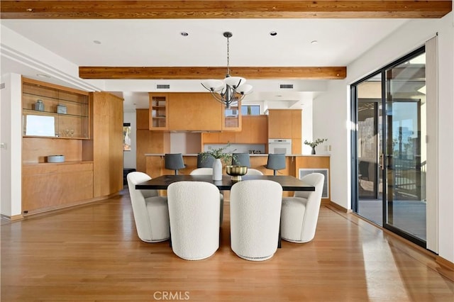 dining area with visible vents, baseboards, beam ceiling, a notable chandelier, and light wood-type flooring