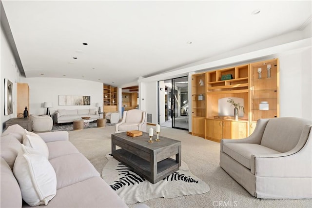 living room with vaulted ceiling, built in features, and light carpet