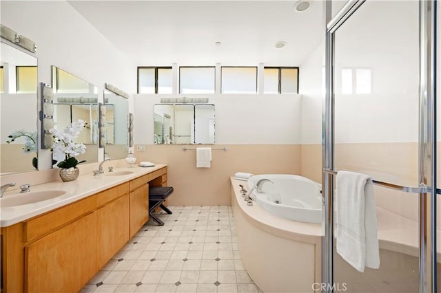 full bath with double vanity, a whirlpool tub, a shower stall, and a sink