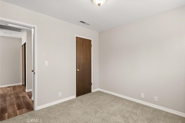 unfurnished bedroom with carpet, baseboards, and visible vents