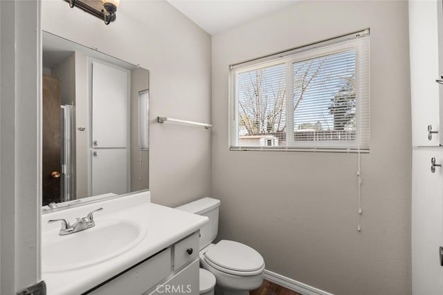 bathroom featuring baseboards, toilet, and vanity