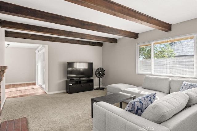 living room featuring baseboards, light carpet, beam ceiling, and a fireplace