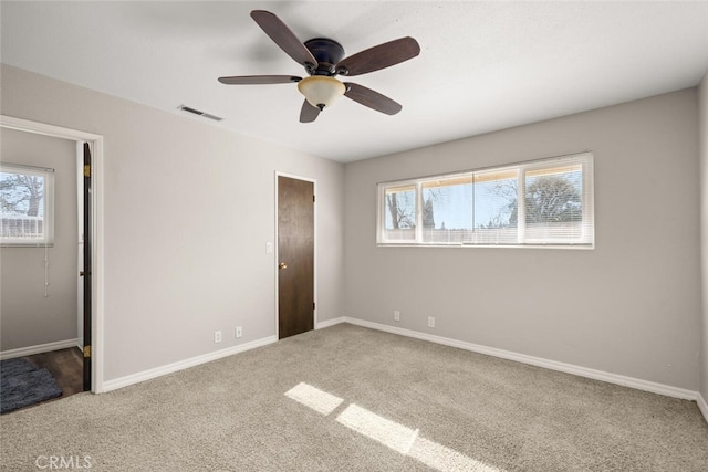 unfurnished bedroom with visible vents, multiple windows, baseboards, and carpet