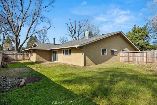 back of house with central air condition unit, a lawn, a fenced backyard, and stucco siding