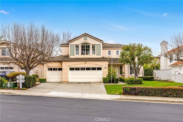 view of front of property with fence, driveway, stucco siding, a garage, and a tiled roof