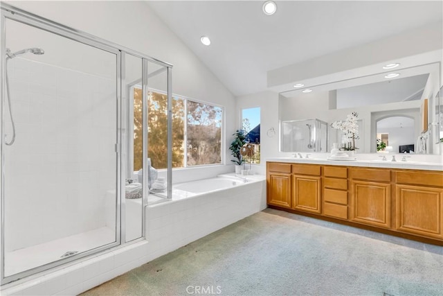 full bathroom with lofted ceiling, a bath, double vanity, and a shower stall