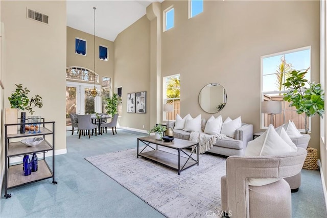 carpeted living room with plenty of natural light, baseboards, visible vents, and a chandelier