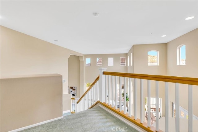 corridor featuring an upstairs landing, recessed lighting, carpet, and baseboards