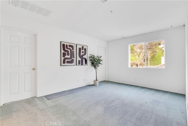 carpeted empty room featuring visible vents