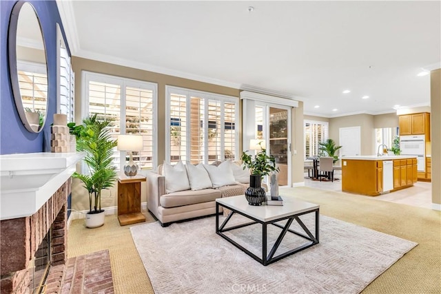 living area with recessed lighting, light colored carpet, crown molding, and baseboards