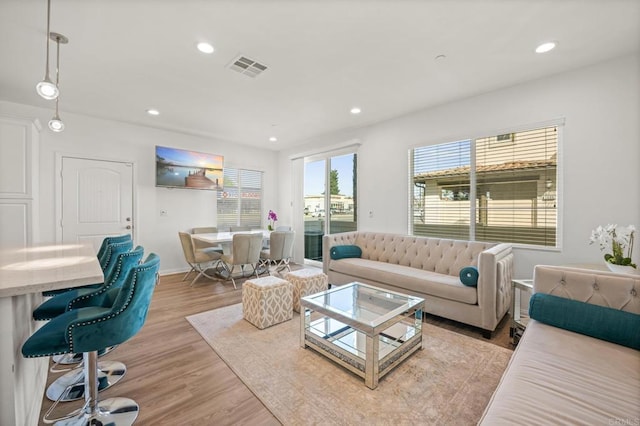 living room featuring recessed lighting, light wood-style floors, visible vents, and baseboards