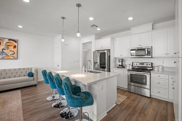 kitchen with a sink, visible vents, appliances with stainless steel finishes, and white cabinets