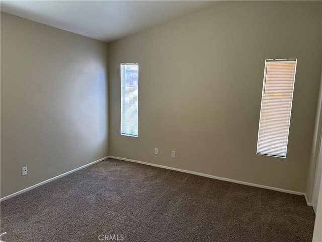 spare room featuring baseboards and carpet flooring