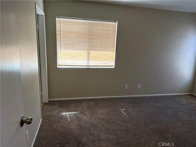 carpeted spare room with baseboards