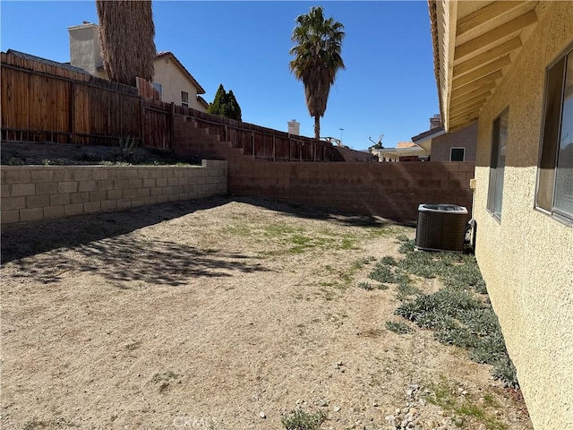 view of yard with central AC unit and a fenced backyard