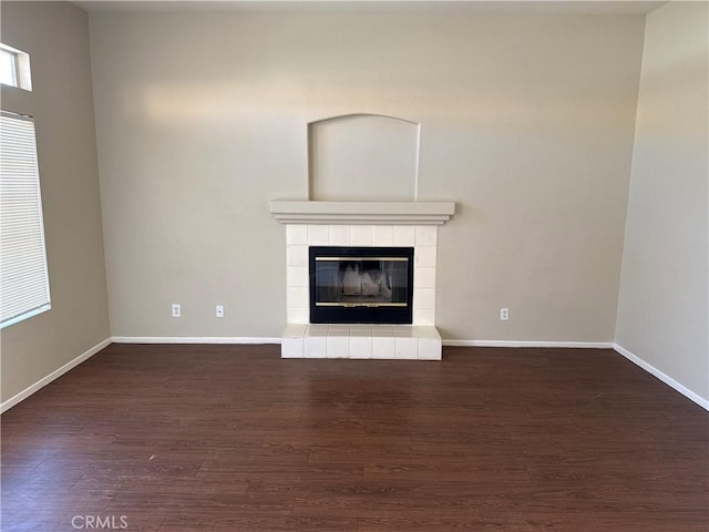 unfurnished living room featuring a fireplace, wood finished floors, and baseboards