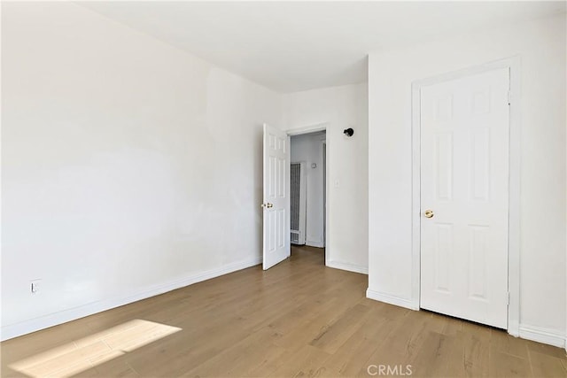 unfurnished bedroom featuring light wood-style floors and baseboards