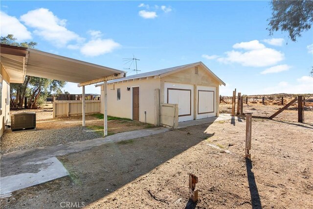 view of outbuilding with central air condition unit, an outdoor structure, and fence