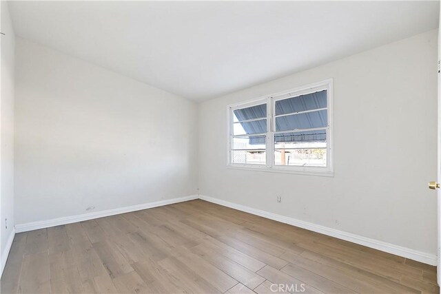 unfurnished room with baseboards and wood finished floors