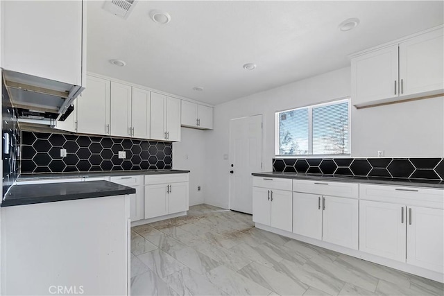 kitchen with visible vents, marble finish floor, white cabinetry, dark countertops, and tasteful backsplash