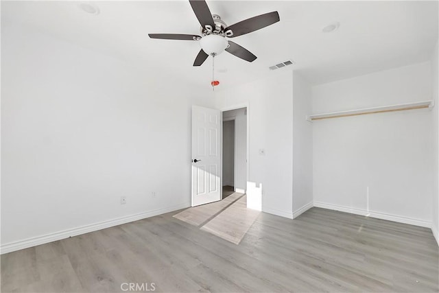 empty room featuring visible vents, ceiling fan, baseboards, and wood finished floors