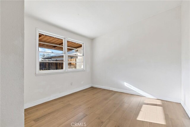 empty room featuring baseboards and wood finished floors