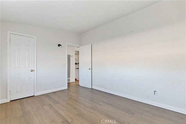 unfurnished bedroom featuring light wood-style flooring and baseboards