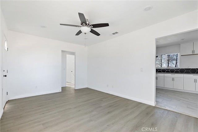 unfurnished living room with visible vents, baseboards, and light wood-style floors