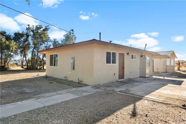 view of property exterior with stucco siding and a patio area