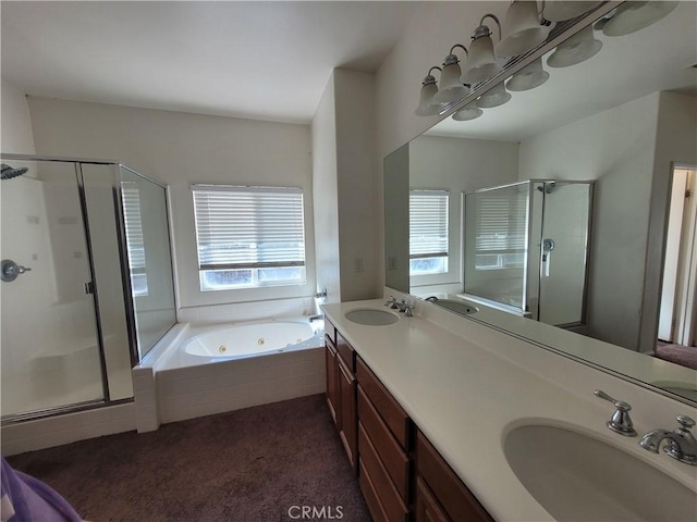 bathroom featuring a shower stall, a tub with jets, and a sink