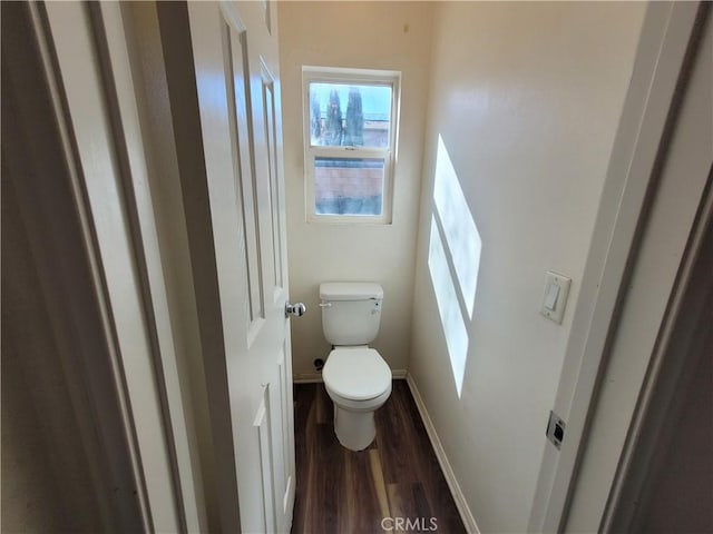 bathroom featuring toilet, wood finished floors, and baseboards