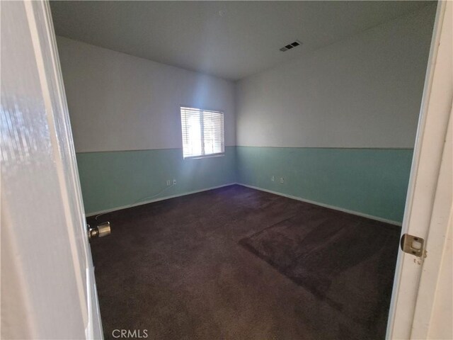 spare room with baseboards, visible vents, and carpet floors