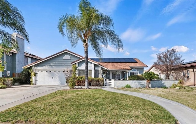 ranch-style home featuring concrete driveway, a tile roof, a front yard, roof mounted solar panels, and a garage