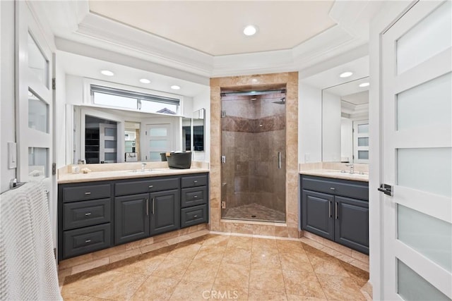 full bath featuring a sink, two vanities, a shower stall, and crown molding