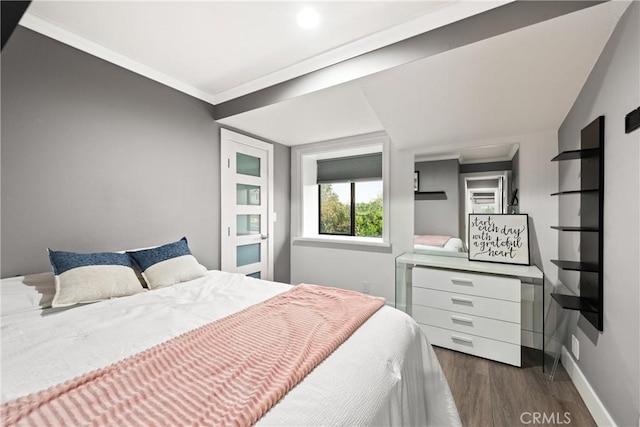 bedroom featuring dark wood-type flooring, crown molding, and baseboards