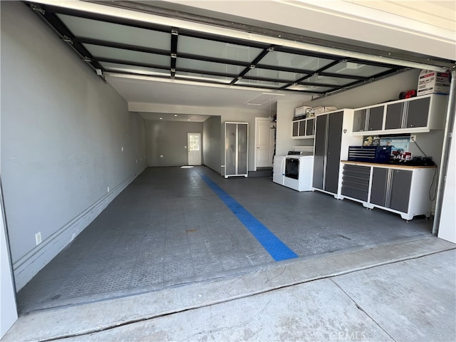 garage featuring washer and dryer and baseboards