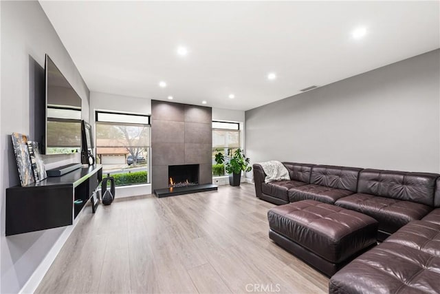 living area featuring visible vents, recessed lighting, a fireplace, and light wood-type flooring