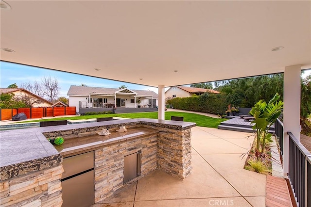 view of patio / terrace featuring an outdoor kitchen and fence