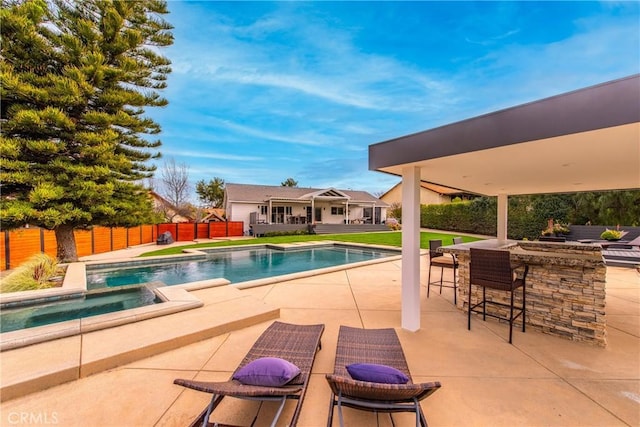 view of pool with outdoor dry bar, a fenced backyard, a fenced in pool, and a patio