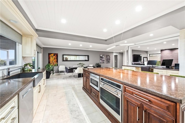 kitchen with ornamental molding, recessed lighting, stainless steel appliances, a raised ceiling, and a sink