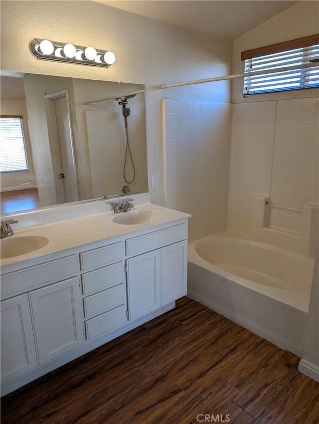 full bath featuring a sink, plenty of natural light, and wood finished floors