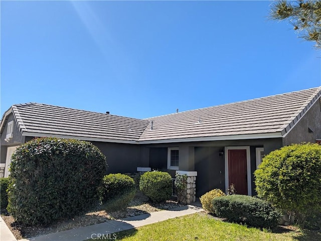 exterior space with stucco siding, a tiled roof, and a garage